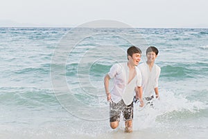 Homosexual portrait young asian couple running with cheerful together on beach in summer