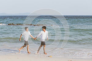 Homosexual portrait young asian couple running with cheerful together on beach in summer