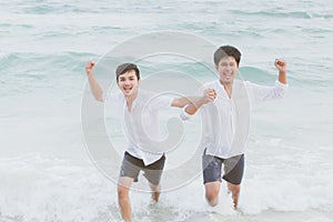 Homosexual portrait young asian couple running with cheerful together on beach in summer