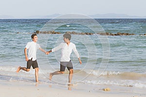 Homosexual portrait young asian couple running with cheerful together on beach in summer