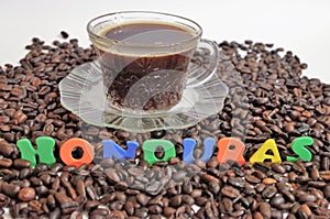 Honduras coffe beans on white surface with a cup of fresh brewed coffe name label 8