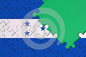 Honduras flag is depicted on a completed jigsaw puzzle with free green copy space on the right side