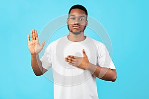 Honest African American Man Doing Swear Gesture Over Blue Background