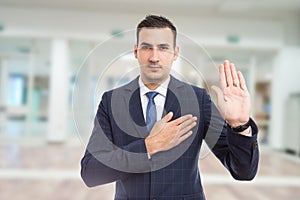 Honest trustworthy real estate agent making oath swear vow gesture. photo
