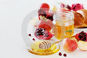 Honey, apple, pomegranate and bread hala, table set with traditional food for Jewish New Year Holiday, Rosh Hashana