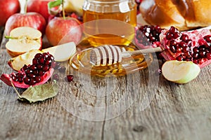 Honey, apple, pomegranate and bread hala, table set with traditional food for Jewish New Year Holiday, Rosh Hashana photo