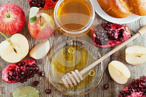 Honey, apple, pomegranate and bread hala, table set with traditional food for Jewish New Year Holiday, Rosh Hashana photo