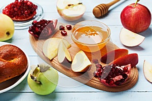 Honey, apple slices, pomegranate and hala. Table set with traditional food for Jewish New Year Holiday, Rosh Hashana. photo