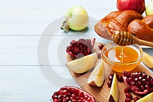 Honey, apple slices, pomegranate and hala. Table set with traditional food for Jewish New Year Holiday, Rosh Hashana. photo