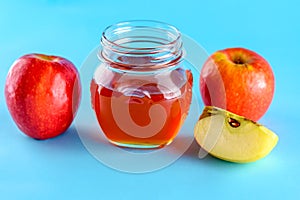 Honey and apples over blue background.