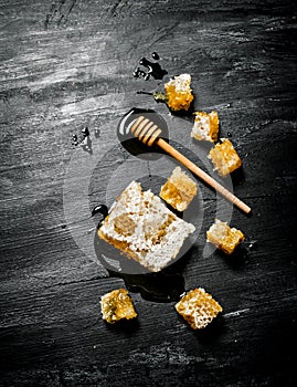 Honey background. Natural honey comb and a wooden spoon .