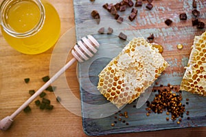 Honey background. Sweet honey in a glass jar, honeycombs, propolis and pollen on the table