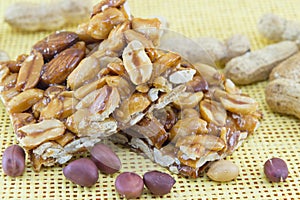 Honey bar with peanuts almonds and hazelnuts surrounded by roast