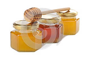 Honey in bottles and wooden dipper