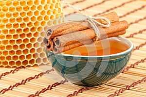 Honey in bowl with honeycomb and cinnamon