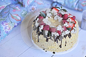 Honey cake, decorated with berries and chocolate. sweet family dinner. holiday cake. on the balcony breakfast