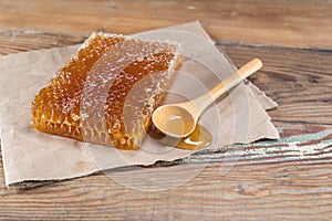 Honey Comb and Spilled Honey on Wooden Board