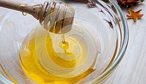 Honey dipper on the bee honeycomb background. Honey tidbit in glass jar and honeycombs wax