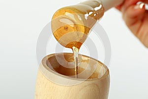 Honey dipper on the bee honeycomb background. Honey tidbit in glass jar and honeycombs wax.