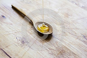 Honey driping into wooden spoon