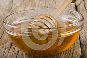 Honey and dripper in a small glass bowl