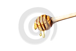 Honey dripping from honey dipper on white background.