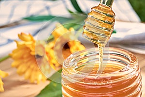 honey dripping from a spoon of honey on bamboo wood