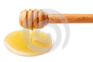 Honey dripping from a wooden dipper