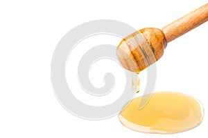 Honey dripping from a wooden dipper on isolate white background