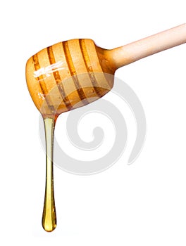 Honey dripping from wooden honey dipper