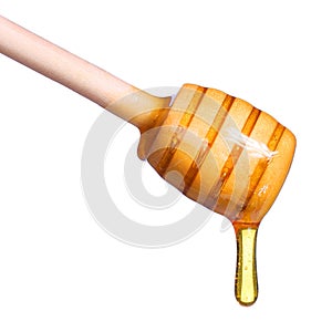 Honey dripping from wooden honey dipper isolated on white