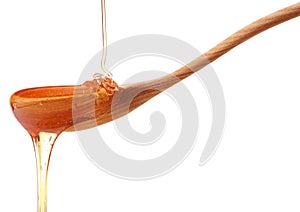 Honey dripping from a wooden honey dipper isolated on white back