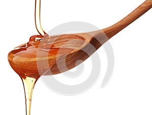 Honey dripping from a wooden honey dipper isolated on white back