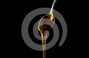 Honey drops from a spoon in a flow