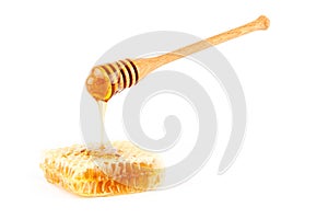 Honey flowing from dipper on honeycomb