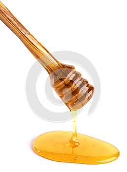 Honey flowing down from a wooden honey dipper