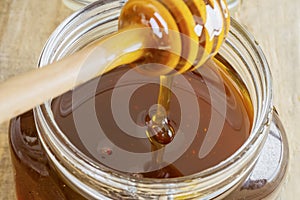 Honey flowing into a glass jar