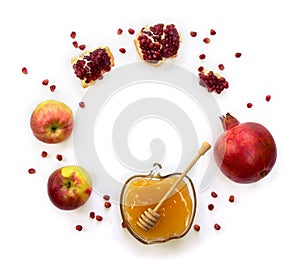 Honey in glass bowl, red apples, garnets, wooden honey dipper on a white background with space for text. Top view, flat lay