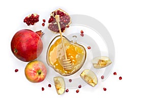 Honey in glass bowl, red apples, garnets, wooden honey dipper on a white background with space for text. Top view, flat lay