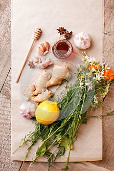 Honey in a glass jar with camomile calendula flowers, ginger root, garlic, anise - immunity tea ingredients, seasonal concept of