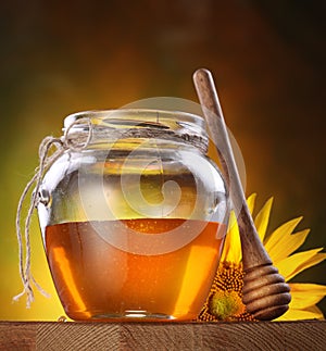 Honey in a glass jar and flower sunflower