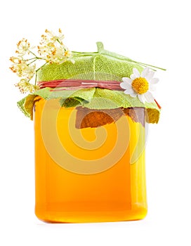 Honey in glass jar with flowers