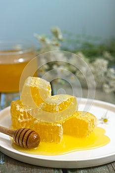 Honey in a glass jar and honey in honeycombs on an old wooden background