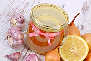 Honey in glass jar, onion, lemon and garlic, healthy nutrition and strengthening immunity