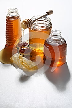 Honey in a glass jar with a wooden stirrer