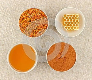 Honey, honeycomb, pollen and cinnamon in bowls