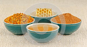 Honey, honeycomb, pollen and cinnamon in bowls