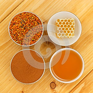 Honey, honeycomb, pollen and cinnamon in bowls