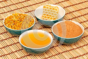 Honey, honeycomb, pollen and cinnamon in bowls