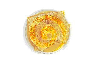 Honey in honeycombs in white of porcelain plate on white background. Top view, flat lay